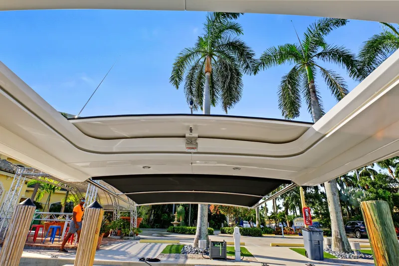 Sensei I Yacht Photos Pics 2021 Sea Ray SLX 400 boat with open sunroof, palm trees in background.