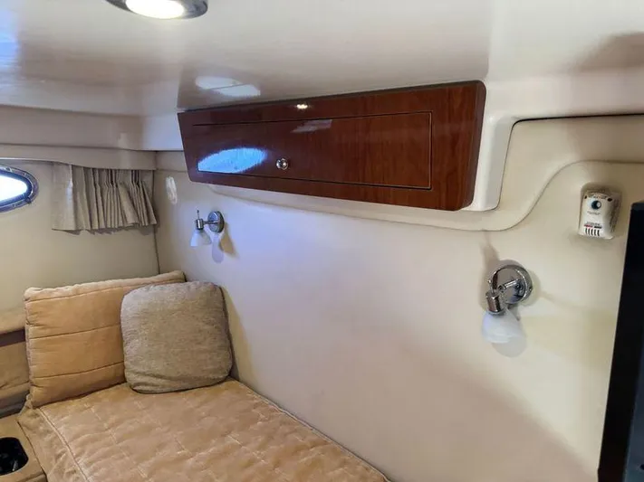 Out With The Buoys II Yacht Photos Pics 2009 Regal Commodore 4060 cabin interior with beige seating and wooden cabinet.