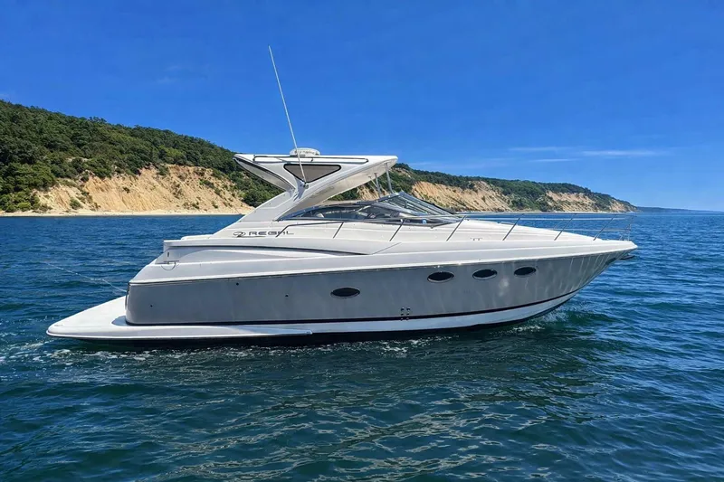 Out With The Buoys II Yacht Photos Pics 2009 Regal Commodore 4060 yacht cruising on blue ocean near scenic coastline.