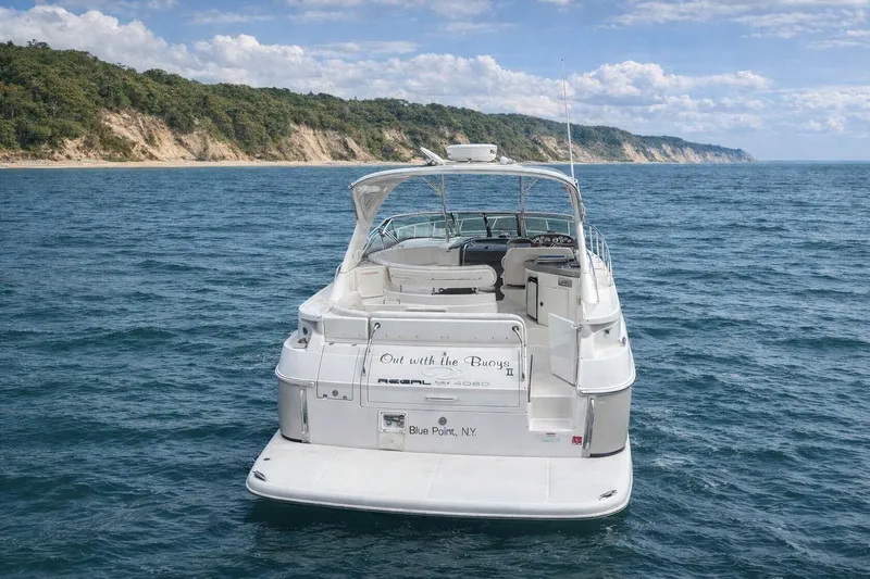 Out With The Buoys II Yacht Photos Pics 2009 Regal Commodore 4060 yacht cruising near scenic coastline under blue sky.