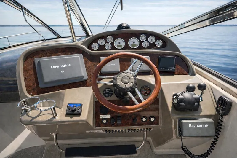 Out With The Buoys II Yacht Photos Pics 2009 Regal Commodore 4060 helm with Raymarine navigation, wood accents, and ocean view.