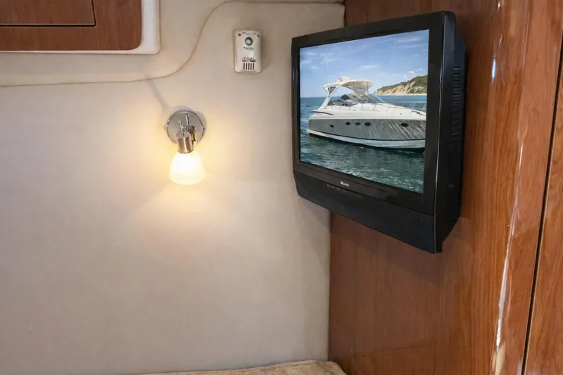 Out With The Buoys II Yacht Photos Pics Interior of 2009 Regal Commodore 4060 with wall-mounted TV and light fixture.