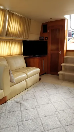 Makin Memories Yacht Photos Pics Interior of 2003 Carver 396 yacht with beige leather seating and a flat-screen TV.