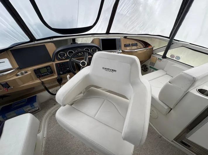 Makin Memories Yacht Photos Pics Interior of a 2003 Carver 396 yacht cockpit with white seating and control panel.