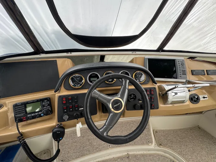 Makin Memories Yacht Photos Pics 2003 Carver 396 helm with steering wheel, gauges, and navigation equipment.