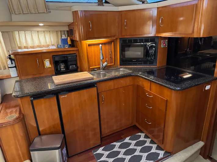 Makin Memories Yacht Photos Pics Luxurious kitchen in 2003 Carver 396 yacht with wood cabinetry and modern appliances.