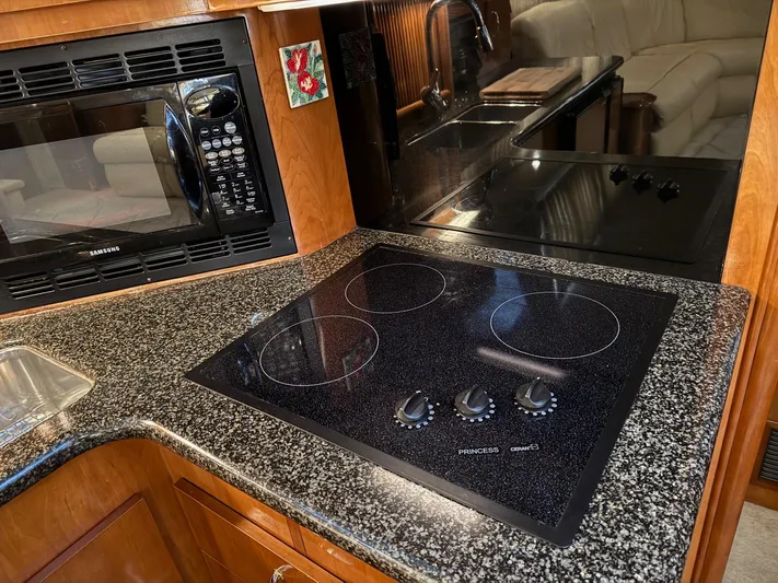 Makin Memories Yacht Photos Pics 2003 Carver 396 yacht kitchen with black cooktop, microwave, and granite countertop.