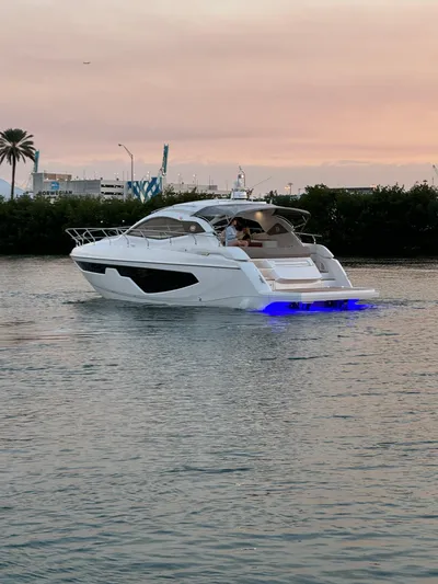  Yacht Photos Pics 2024 Sessa Marine C44 Cruiser on water at sunset with blue underwater lights.