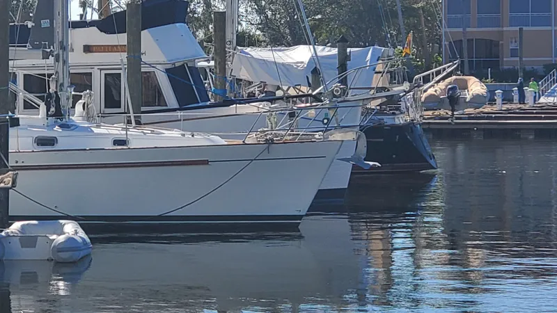  Yacht Photos Pics Beneteau Oceanis 44 CC 1999 sailboat docked in a marina, calm water reflections.