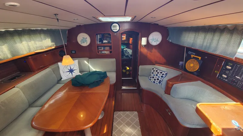  Yacht Photos Pics Interior of 1999 Beneteau Oceanis 44 CC sailboat with cozy seating and wooden finishes.