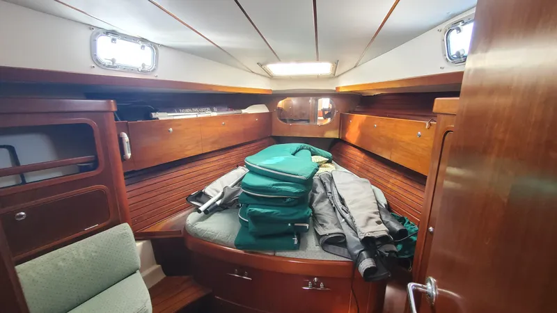  Yacht Photos Pics Cozy cabin interior of 1999 Beneteau Oceanis 44 CC sailboat with wooden finish and storage.