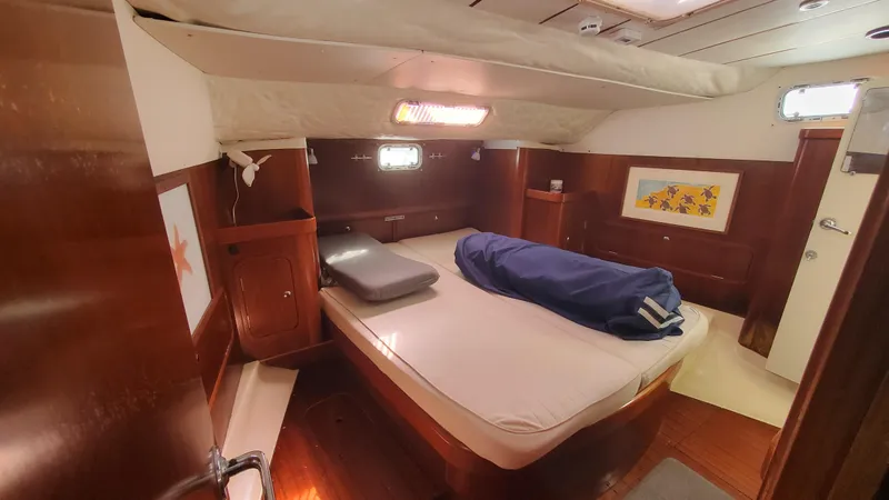  Yacht Photos Pics Interior cabin of 1999 Beneteau Oceanis 44 CC yacht, featuring cozy wooden furnishings.