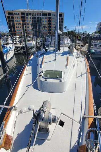  Yacht Photos Pics 1999 Beneteau Oceanis 44 CC sailboat docked at marina, sunny day, modern buildings in background.