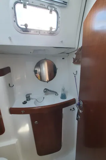  Yacht Photos Pics Bathroom interior of 1999 Beneteau Oceanis 44 CC sailboat, featuring sink and mirror.