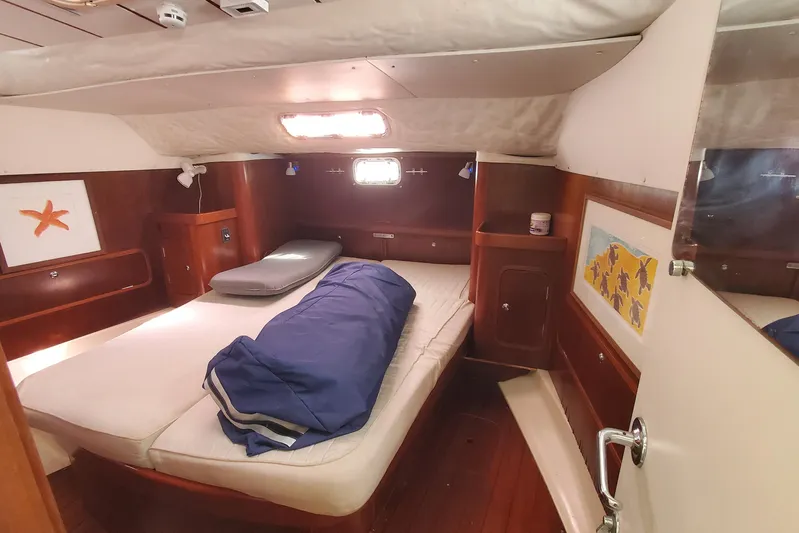  Yacht Photos Pics Cozy cabin interior of 1999 Beneteau Oceanis 44 CC sailboat with bed and wooden furnishings.