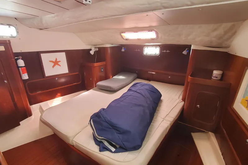  Yacht Photos Pics Cozy cabin interior of 1999 Beneteau Oceanis 44 CC sailboat with bed and wooden finish.