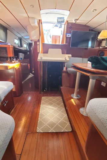  Yacht Photos Pics Interior of 1999 Beneteau Oceanis 44 CC sailboat with wooden flooring and cozy seating area.