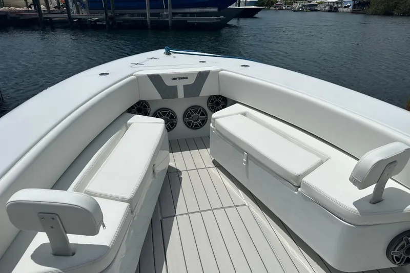  Yacht Photos Pics 2019 Contender 35 ST boat interior with white seating and speakers, docked by the water.