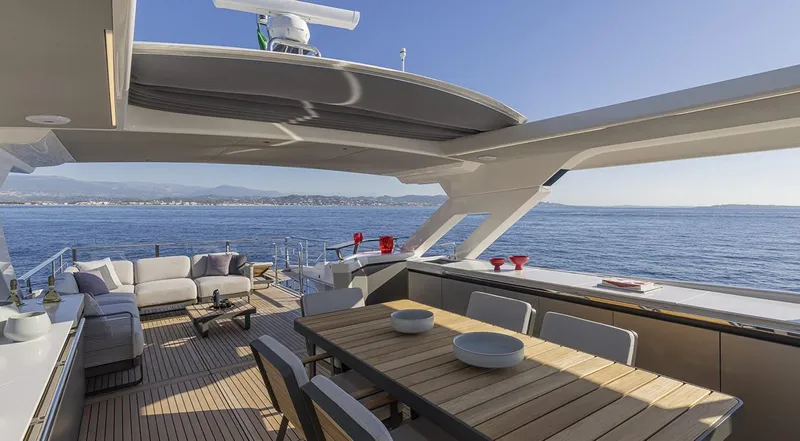 Absolute Navetta 75 Yacht Photos Pics Luxurious 2025 Absolute NAVETTA 75 yacht deck with elegant seating and dining area, overlooking the ocean.
