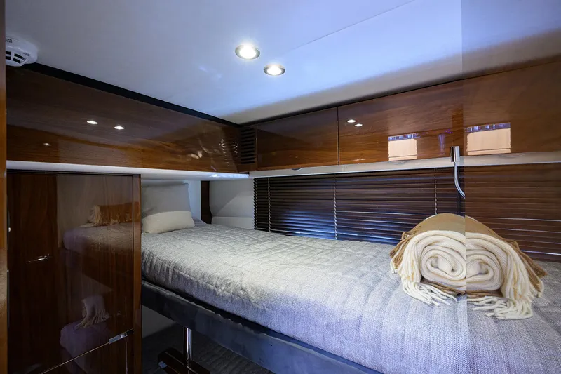 Gallant Lady Yacht Photos Pics Luxurious cabin interior of 2018 Princess 65S yacht with cozy bedding and elegant wood finishes.