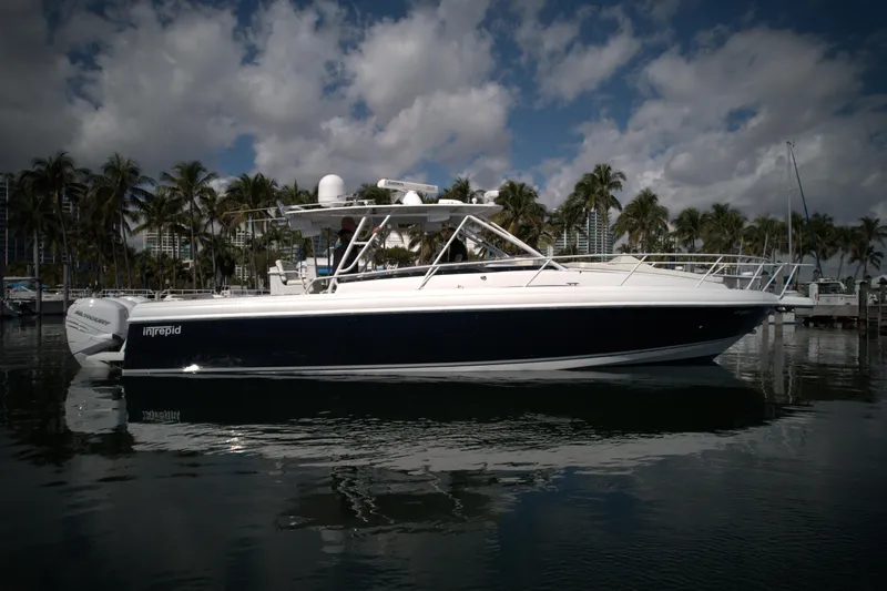 377 Walkaround Cuddy Yacht Photos Pics 2002 Intrepid 377 Walkaround Cuddy boat docked in a marina with palm trees.