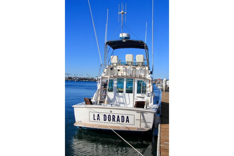 La Dorada Yacht Photos Pics 1980 Bertram 35 Flybridge boat docked, rear view with "La Dorada" nameplate.