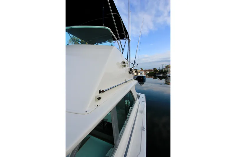 La Dorada Yacht Photos Pics 1980 Bertram 35 Flybridge boat docked, showcasing sleek design and calm waters.