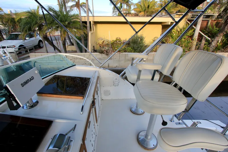La Dorada Yacht Photos Pics 1980 Bertram 35 Flybridge with white seating and Simrad navigation system.