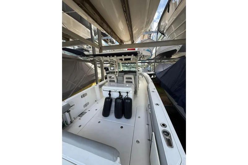  Yacht Photos Pics 2016 Boston Whaler 330 Outrage boat interior with seating and storage, docked in a marina.