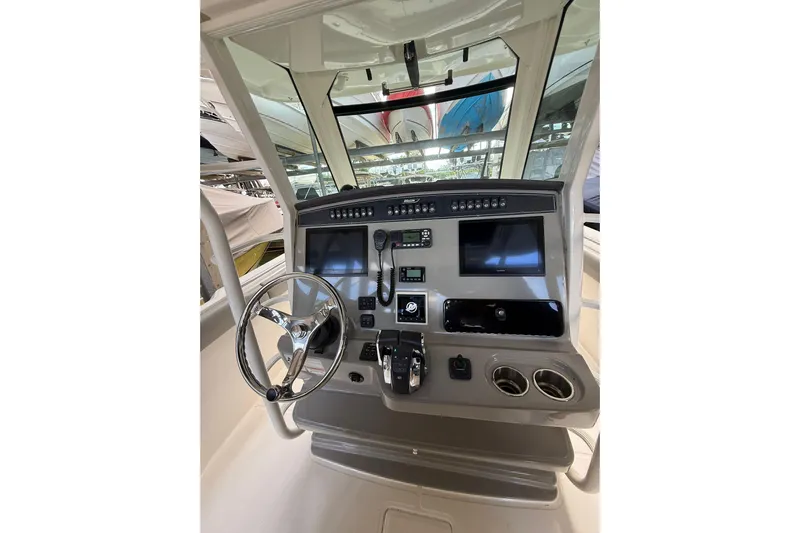  Yacht Photos Pics 2016 Boston Whaler 330 Outrage helm with steering wheel, controls, and navigation displays.