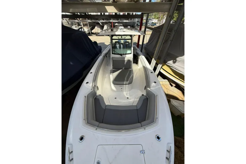  Yacht Photos Pics 2016 Boston Whaler 330 Outrage boat, docked under a shelter, showcasing spacious deck.