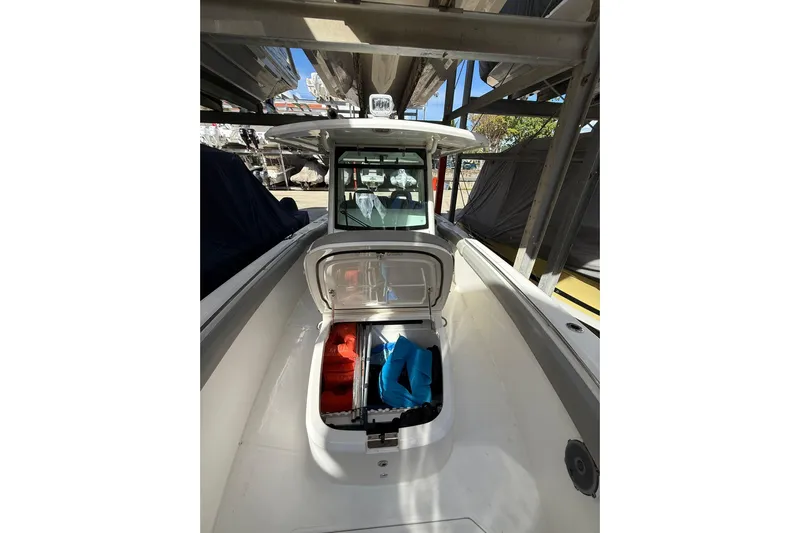  Yacht Photos Pics 2016 Boston Whaler 330 Outrage boat with open storage compartment, docked under cover.