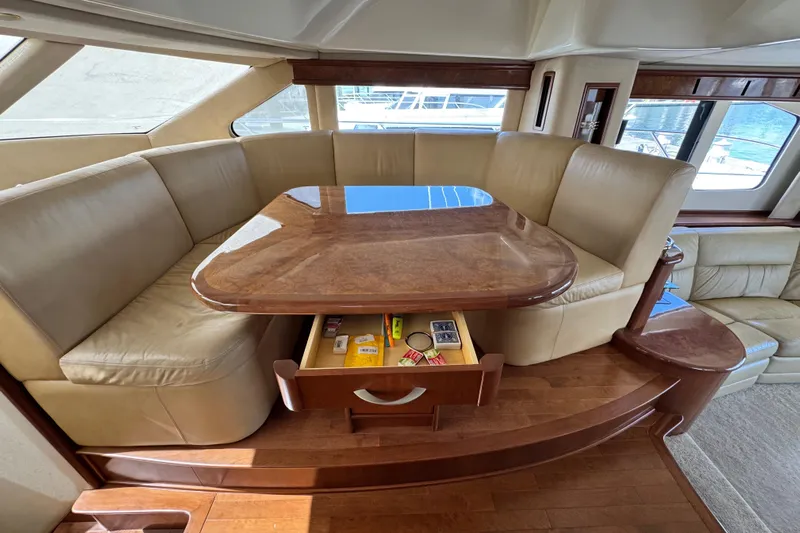  Yacht Photos Pics Luxurious seating area on 2009 Ovation 52 yacht with wooden table and storage drawer.