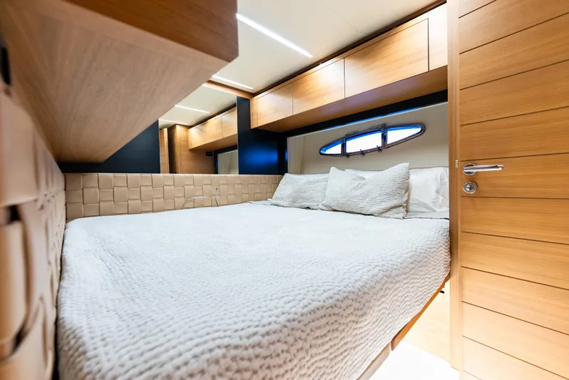  Yacht Photos Pics Luxurious bedroom interior on a 2012 Pershing 92 yacht, featuring elegant wood finishes.