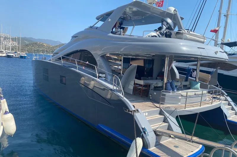  Yacht Photos Pics Luxurious 2012 Sunreef 60 yacht docked at a marina, featuring sleek design and spacious deck.