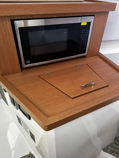  Yacht Photos Pics Microwave in Schaefer 303 Sport boat, 2023 model, with wooden cabinetry.