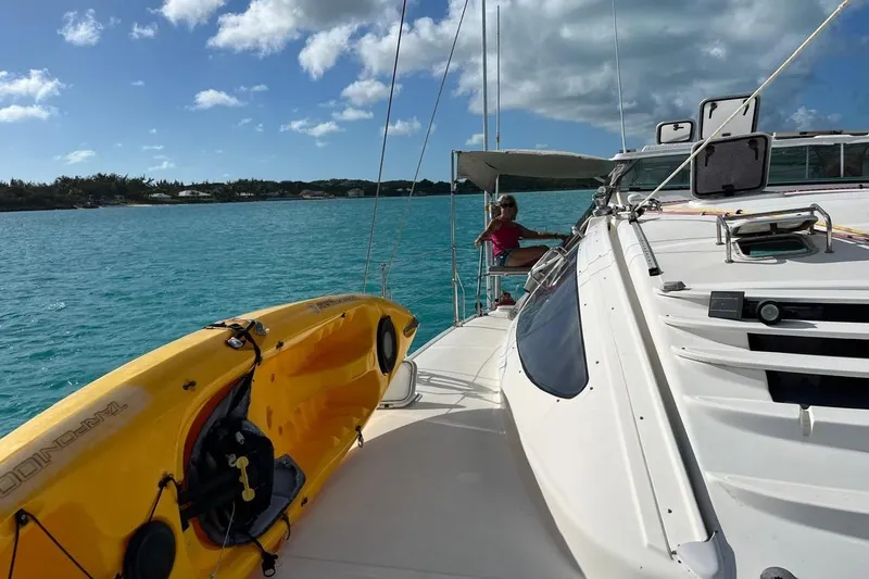 Alleycat Yacht Photos Pics 2004 Island Spirit 400 catamaran with kayak on deck, sailing in clear blue waters.