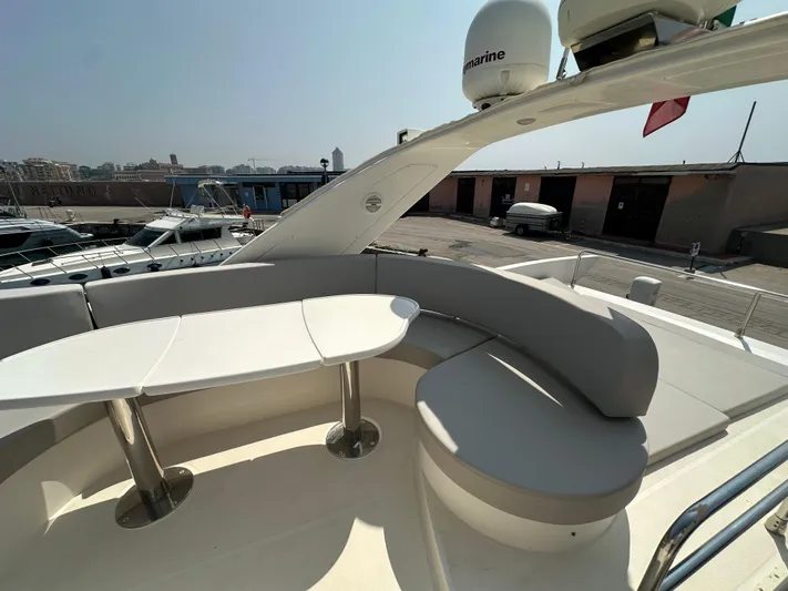 Azimut Benetti Fly 50 Yacht Photos Pics Flybridge seating area on a 2006 Azimut 50 yacht, featuring a curved bench and table.