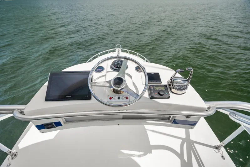 King's Ransom Yacht Photos Pics Helm of 2004 Cabo 40 Express boat with steering wheel and navigation equipment.