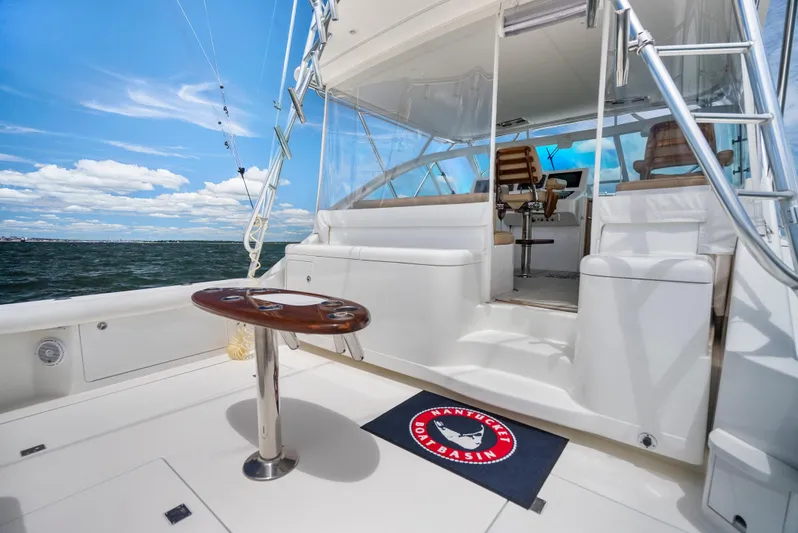 King's Ransom Yacht Photos Pics 2004 Cabo 40 Express yacht deck with seating, table, and ocean view under blue sky.