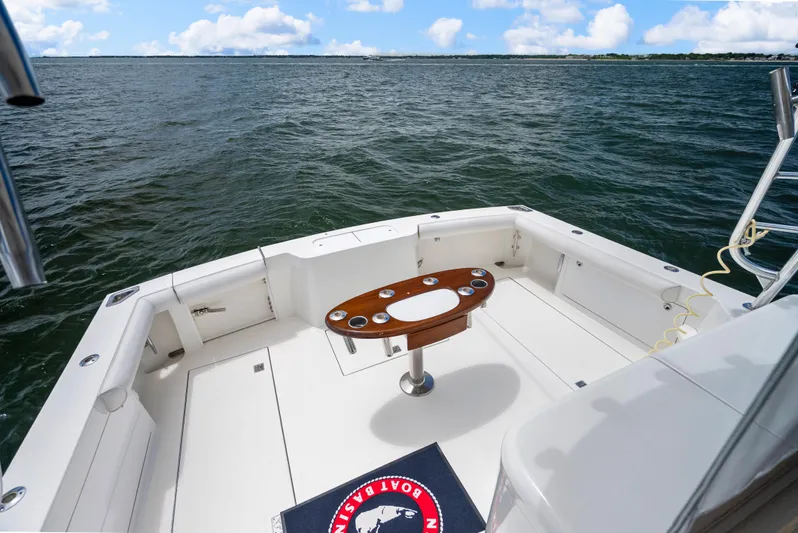 King's Ransom Yacht Photos Pics 2004 Cabo 40 Express boat deck with ocean view, featuring a central table and rod holders.