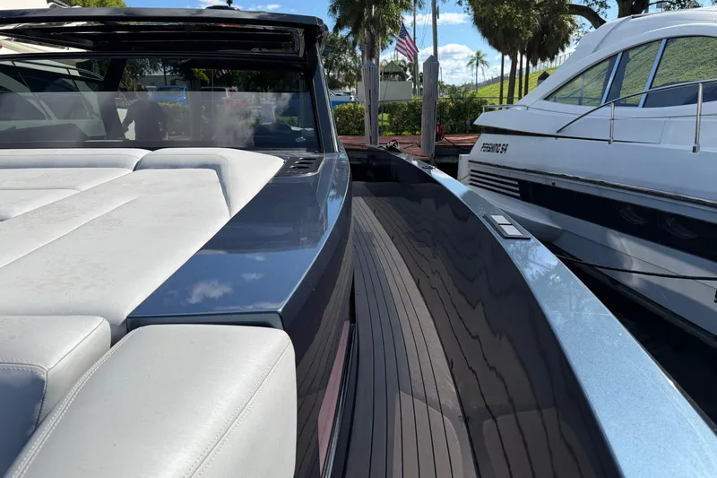  Yacht Photos Pics 2022 Vanquish VQ45 luxury yacht with sleek design and spacious deck, docked beside another vessel.