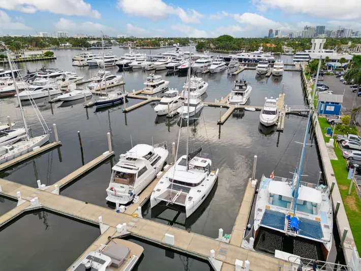 Neptune's Waters Yacht Photos Pics 2019 Lagoon 42 catamaran docked in marina, surrounded by boats.