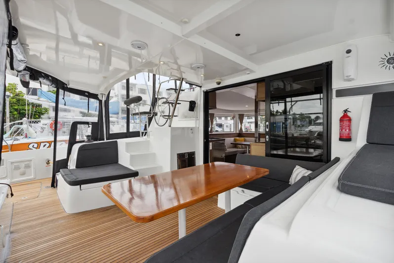 Neptune's Waters Yacht Photos Pics Interior of a 2019 Lagoon 42 yacht with wooden table and seating area.