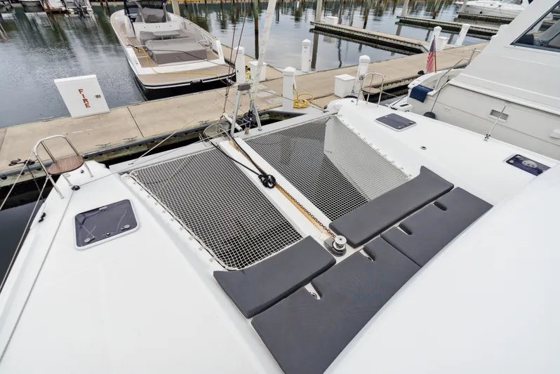 Neptune's Waters Yacht Photos Pics 2019 Lagoon 42 catamaran in harbor, netting and seating area visible.