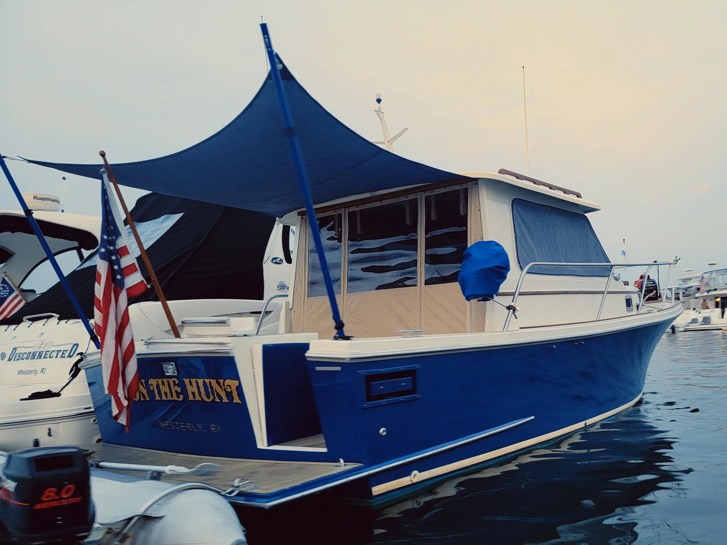2000 Hunt Yachts 29 boat with blue hull and canopy, docked in a marina.