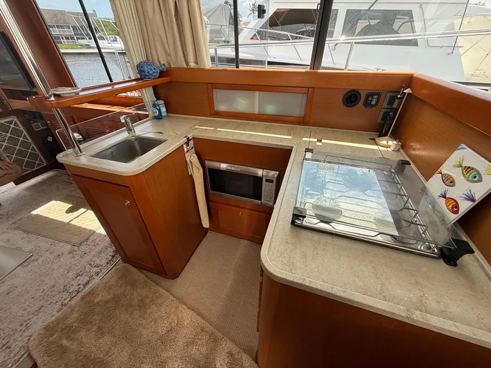 Wanderer Yacht Photos Pics 2016 Beneteau Swift Trawler 44 kitchen with sink, stove, and wooden cabinetry.