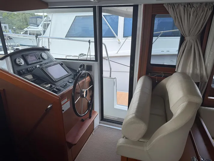 Wanderer Yacht Photos Pics Interior helm of 2016 Beneteau Swift Trawler 44 with steering wheel and navigation equipment.