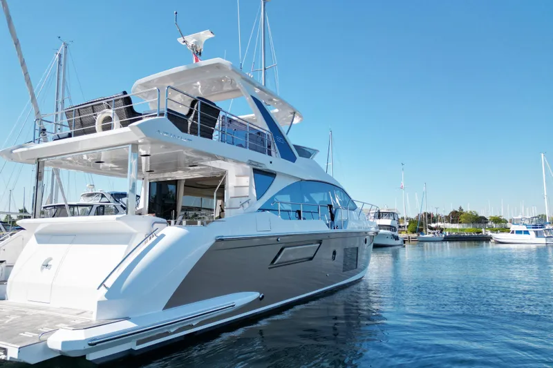  Yacht Photos Pics 2024 Azimut Fly 60 yacht docked in a marina under clear blue skies.