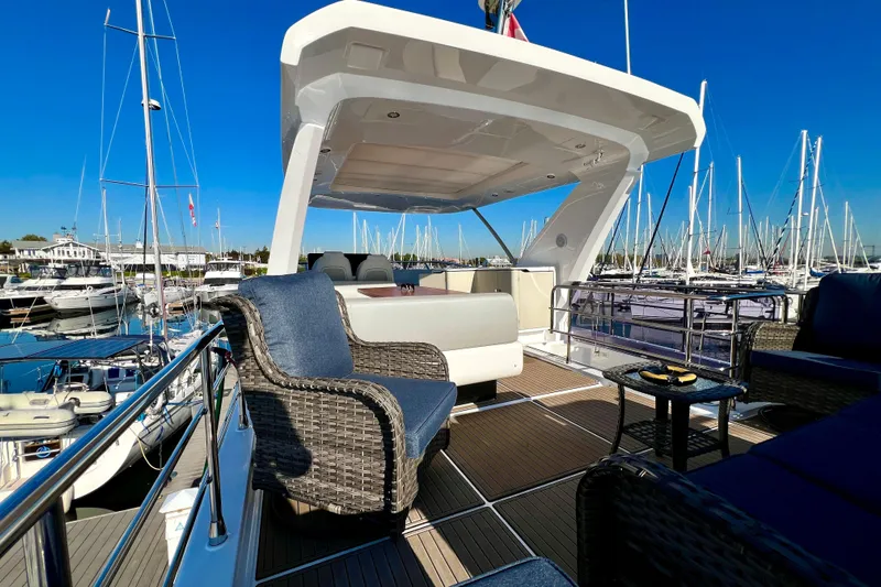  Yacht Photos Pics Luxurious 2024 Azimut Fly 60 yacht deck with elegant seating, docked in a marina.